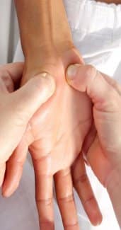 A woman is receiving a deep tissue massage from another person.