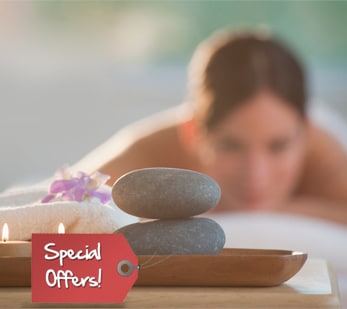 A woman is enjoying the special seasonal offer as she lies on a bed surrounded by stones.