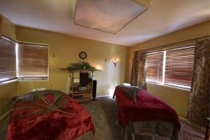 Description: Indulge in a couples massage experience with two massage beds in a room adorned with elegant curtains. Perfect for those seeking a romantic retreat or looking to pamper themselves and their loved one
