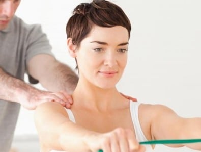 A woman is being assisted by a pilates instructor during her physical therapy session in Fort Lauderdale.