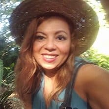 A woman in a straw hat poses for a photo.