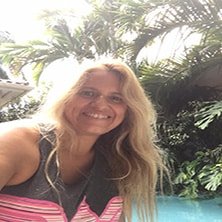 A woman is taking a selfie in front of a pool.