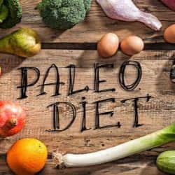 The word paleo diet is written on a wooden table.