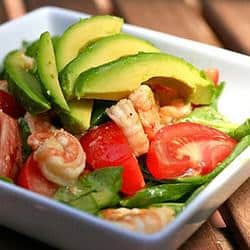A salad with shrimp, tomatoes and avocado.