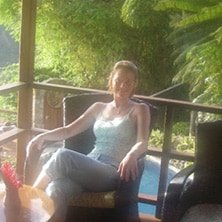 A woman sitting in a chair on a porch.