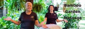 Two women standing in front of a bamboo garden with the words bamboo garden massage.