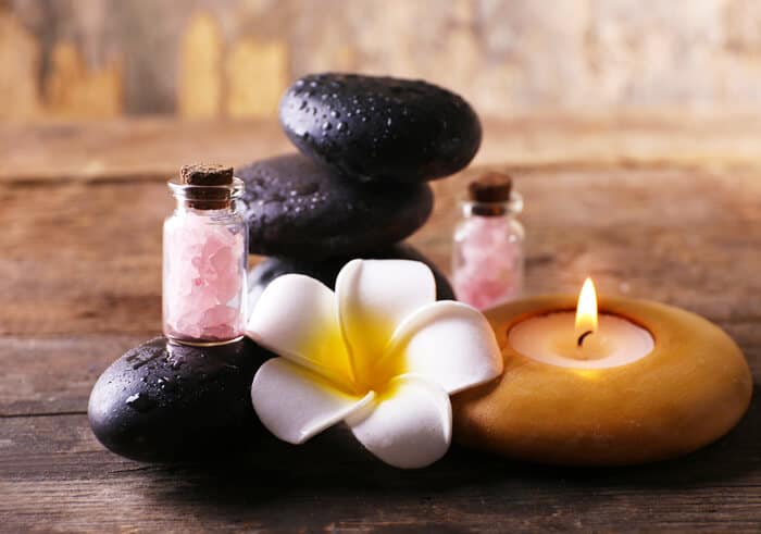 A spa table with a candle and a flower.