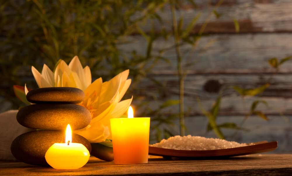 A spa table with candles and a lotus flower.