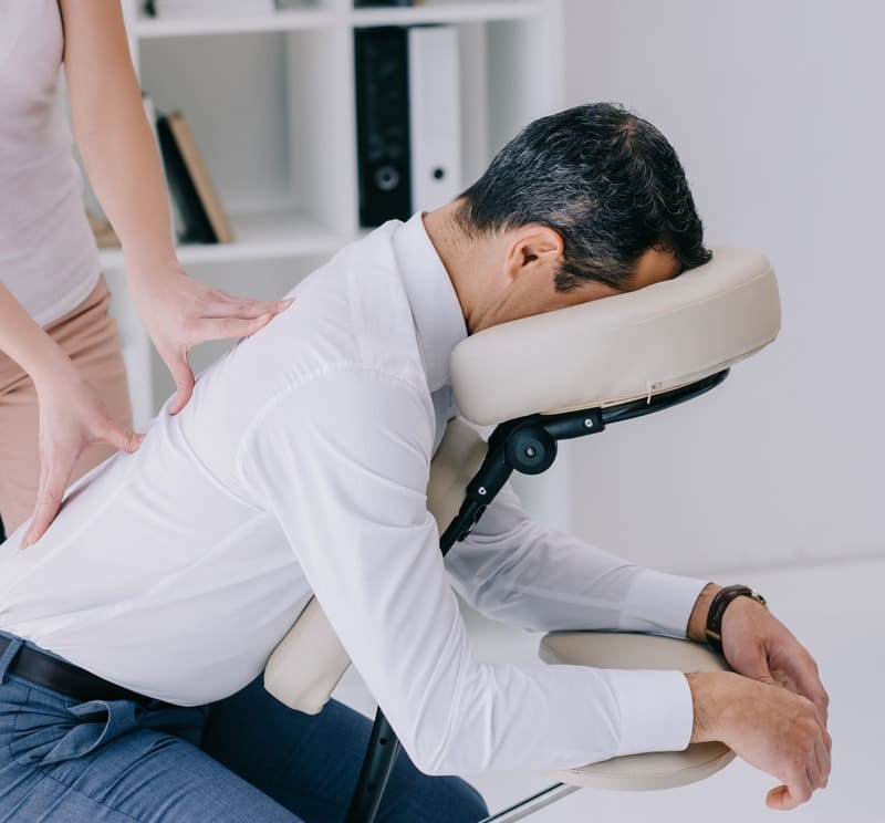 A man sitting on a chair with his head on his back.