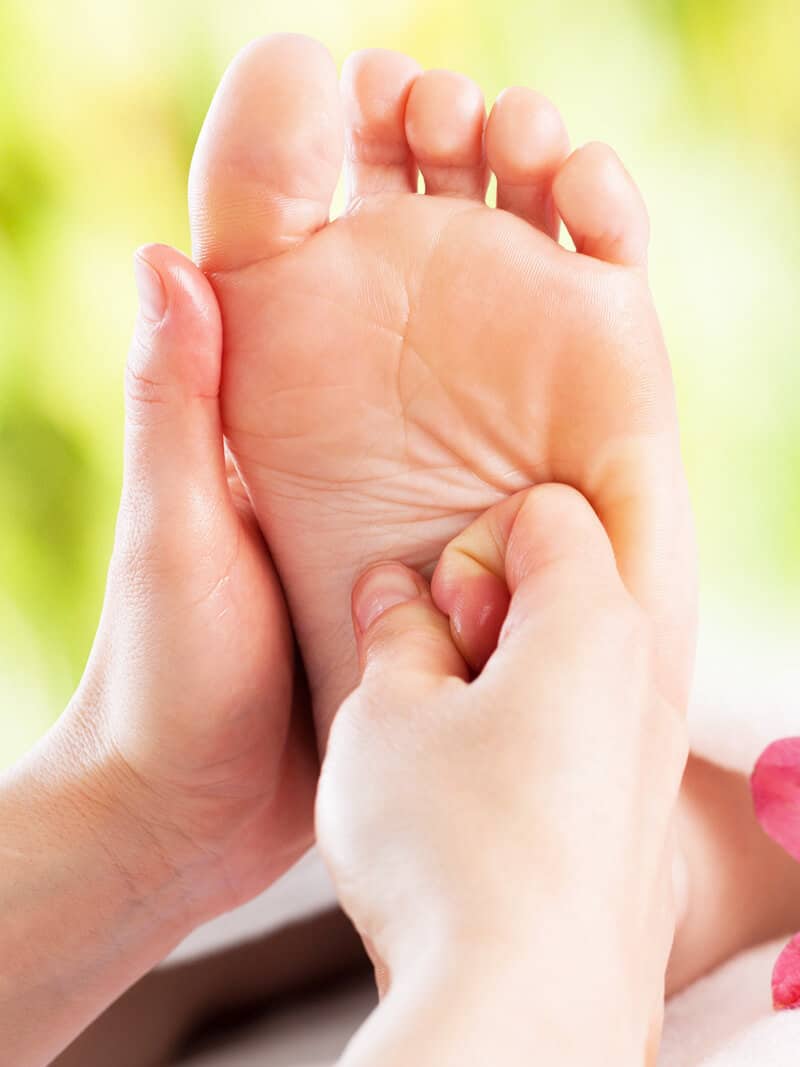 A woman getting a foot massage in a spa.