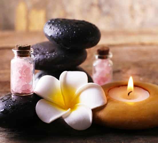 A candle and stones with a flower and salt.