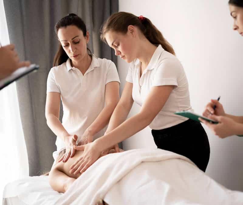 A woman massaging a woman's back.